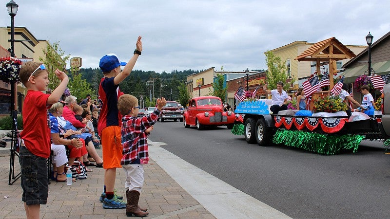 Young boys wave at passing float during parade